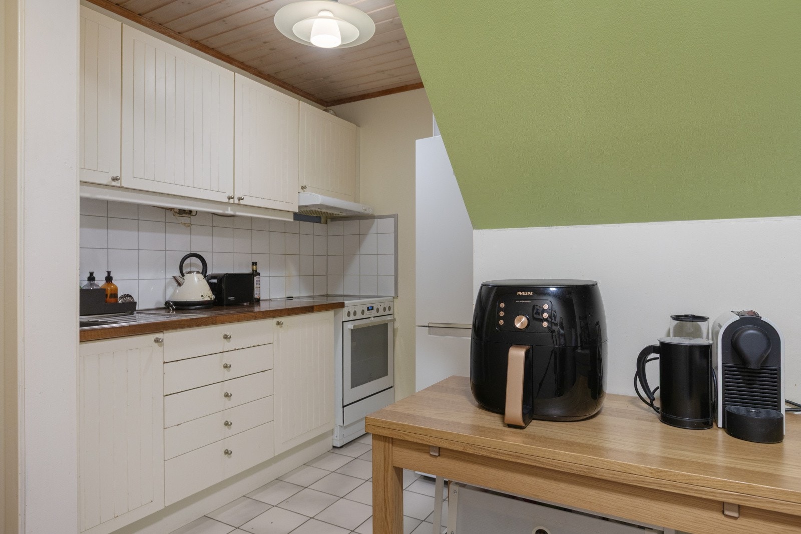 Kjøkkenet i utleiedel som har en praktisk, men eldre innredning med profilerte fronter og laminatbenkeplate. Galleribilde