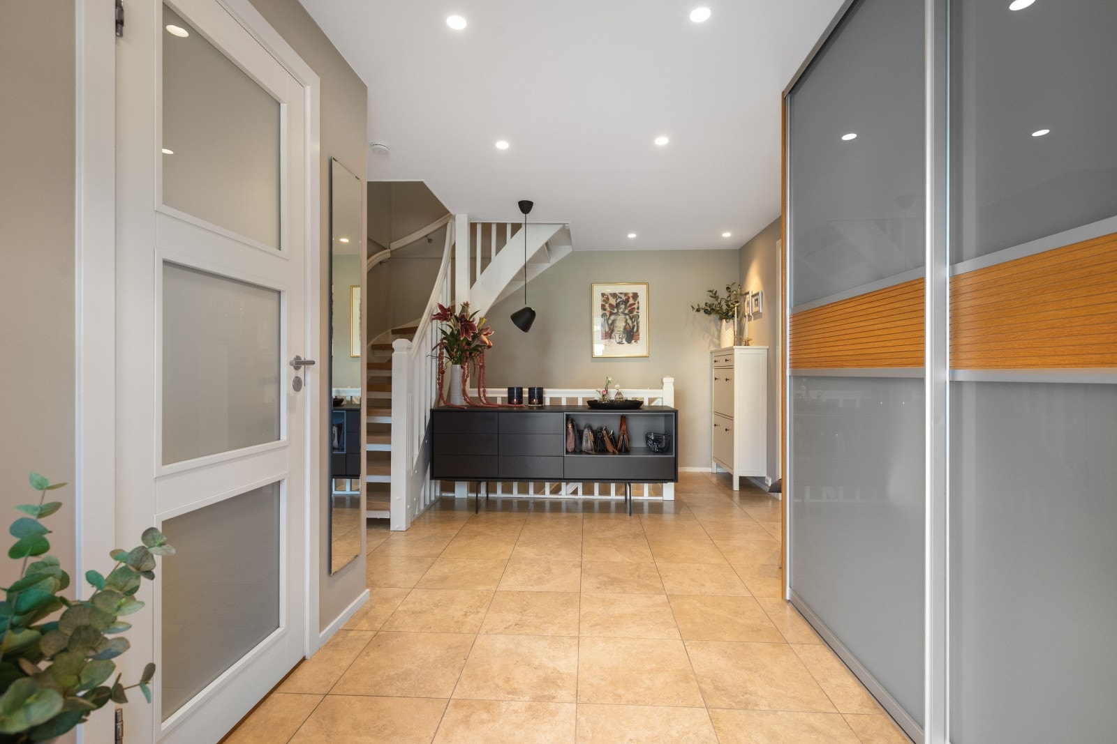 Entré/hall med flislagt gulv med varme og romslig skyvedørsgarderobe som kan legge til rette for en ryddig og behagelig inngang til boligen. Galleribilde