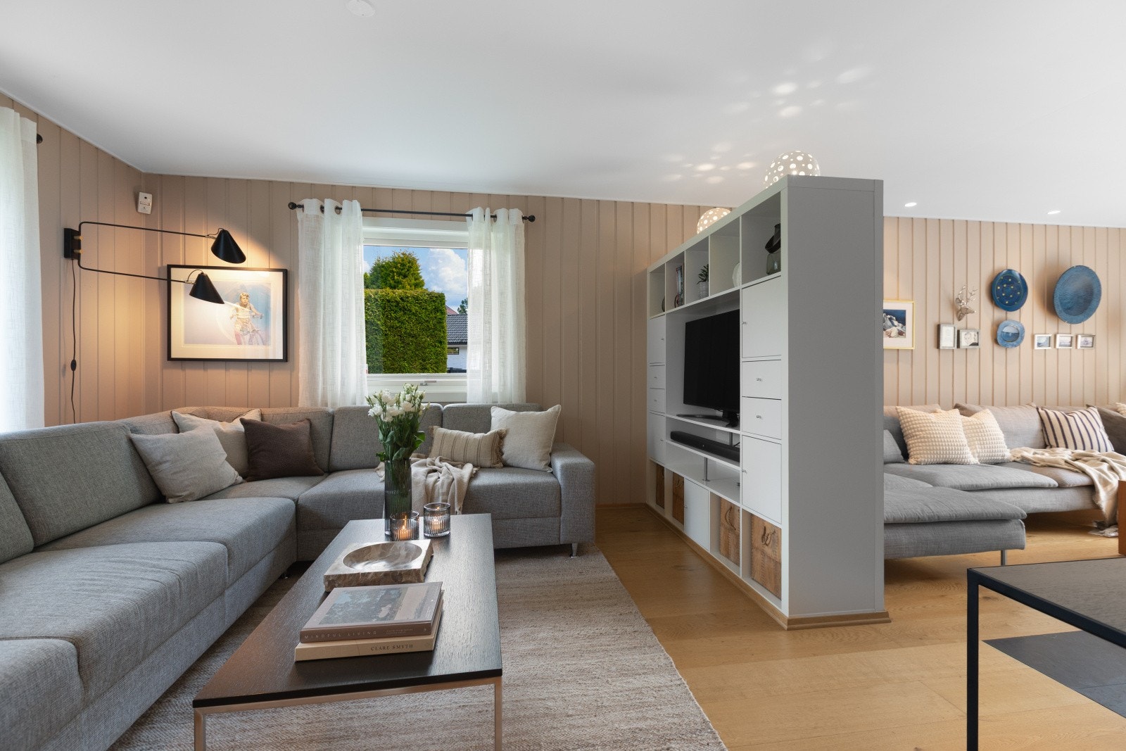 I stuen er det i dag en halvvegg som legger til rette for flere soner og som fungerer fint som et tv-møblement. Galleribilde