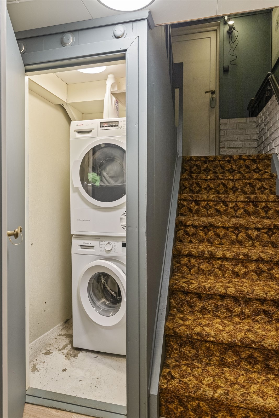 Praktisk bod under trappen i kjelleren, med plass til vaskemaskin og tørketrommel Galleribilde