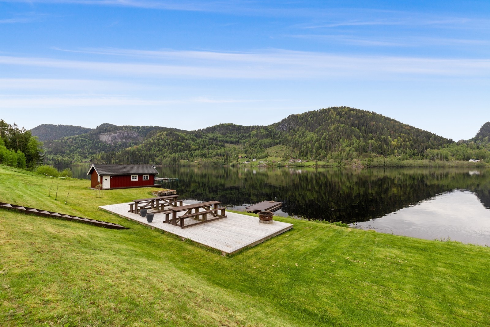 Flotte fellesareal utenfor leiligheten med benker, brygge og grøntareal. Galleribilde
