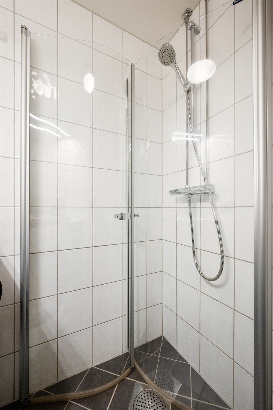 Ellers er badet innredet med dusjhjørne, vegghengt toalett og opplegg for vaskemaskin. Galleribilde