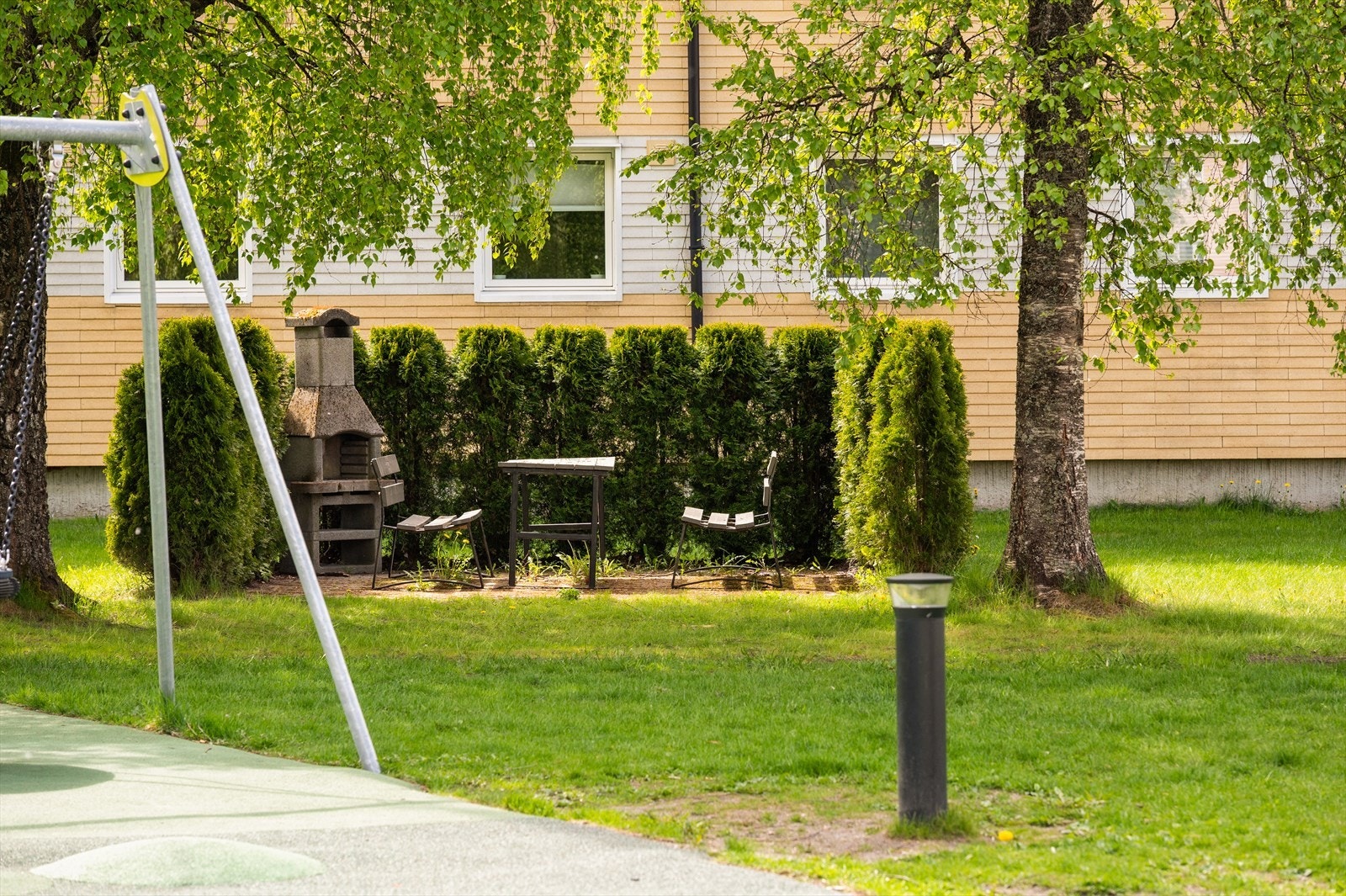Opparbeidede fellesarealer i borettslaget med bord, benker og lekeplasser. Galleribilde