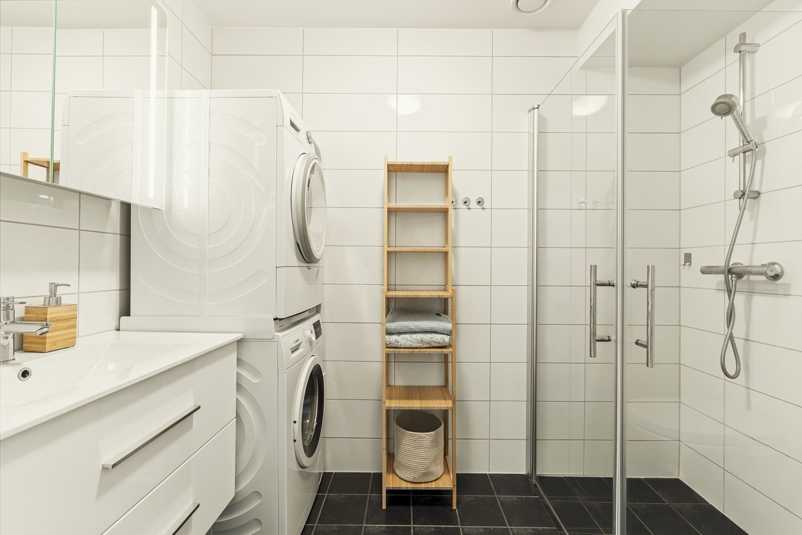 Stilrent, flislagt bad i hybelen med varmekabler og opplegg for vaskemaskin. Galleribilde