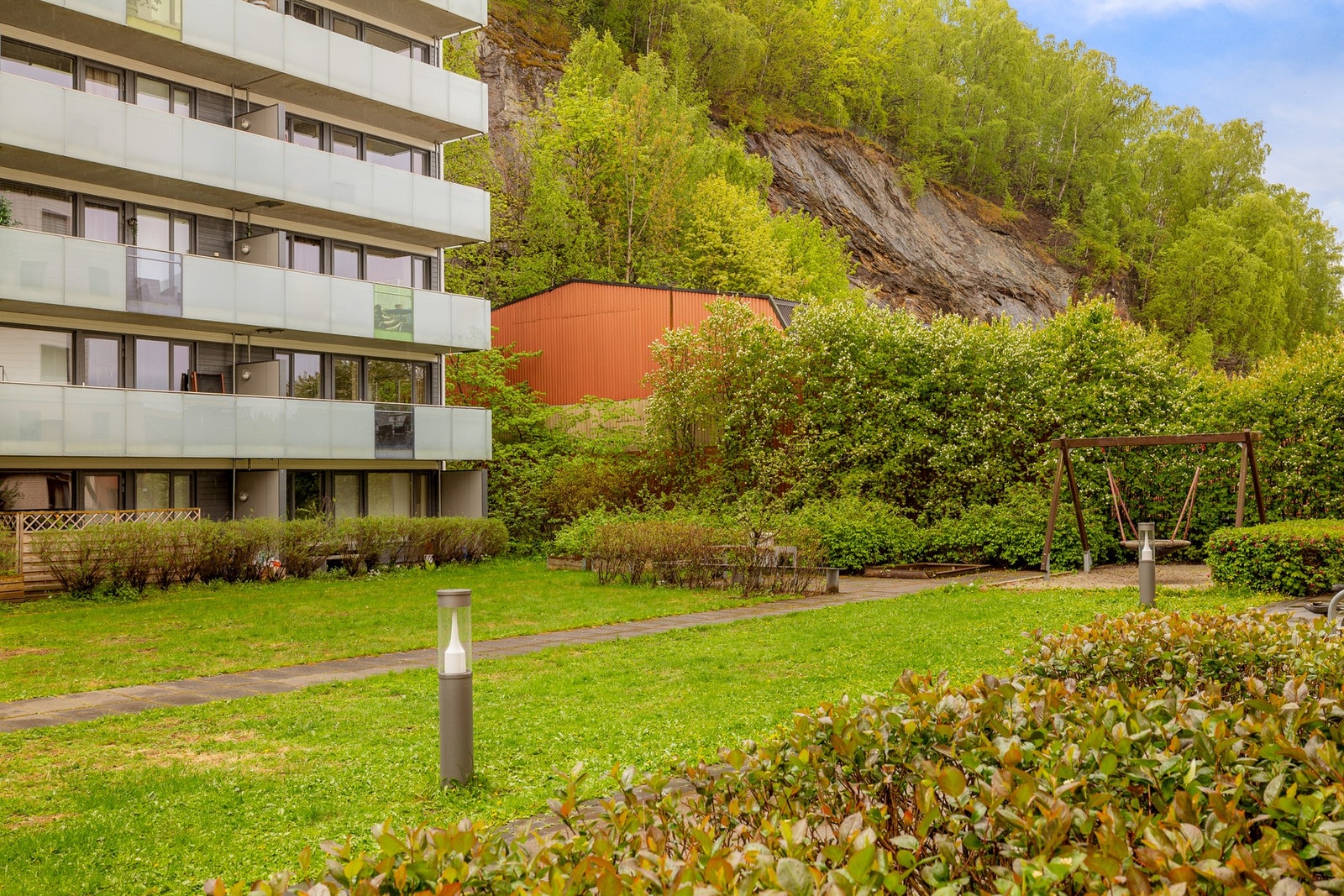 Felles tomt opparbeidet med blant annet støpte veier og trapper, lekeplass, sittegrupper, plenarealer og andre forskjellige beplantninger. Galleribilde