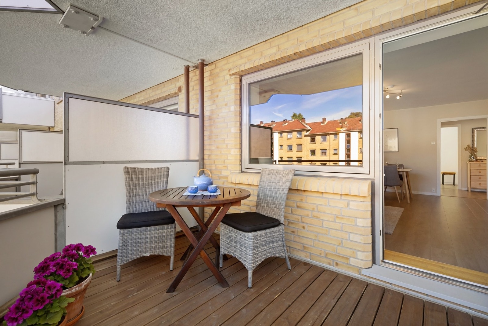 Balkongen gir plass til grill, ulik møblering og har terrassebord samt levegger på siden. Galleribilde