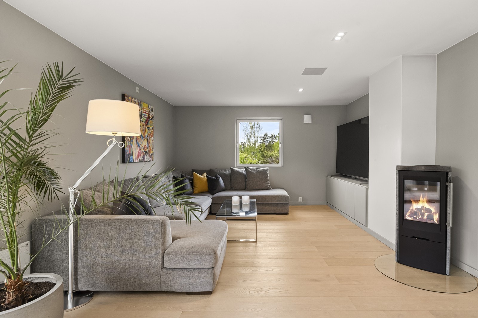 Sofahjørnet har plass til en stor sofa for hele familien, og en pen vedovn sørger for ekstra varme og peishygge. Plassbygget skapoppbevaring under tv. Galleribilde