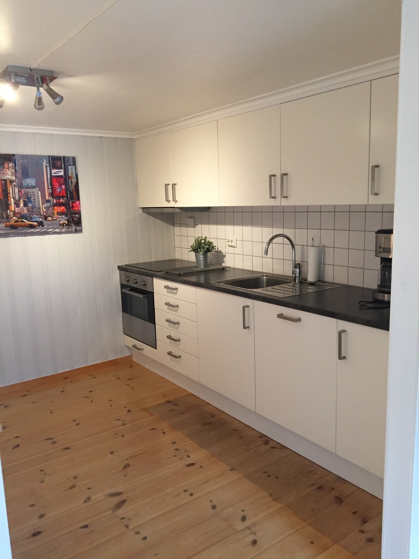 Kjøkkenet har innredning med glatte fronter, laminat benkeplate og er utstyrt med hvitevarer. Galleribilde