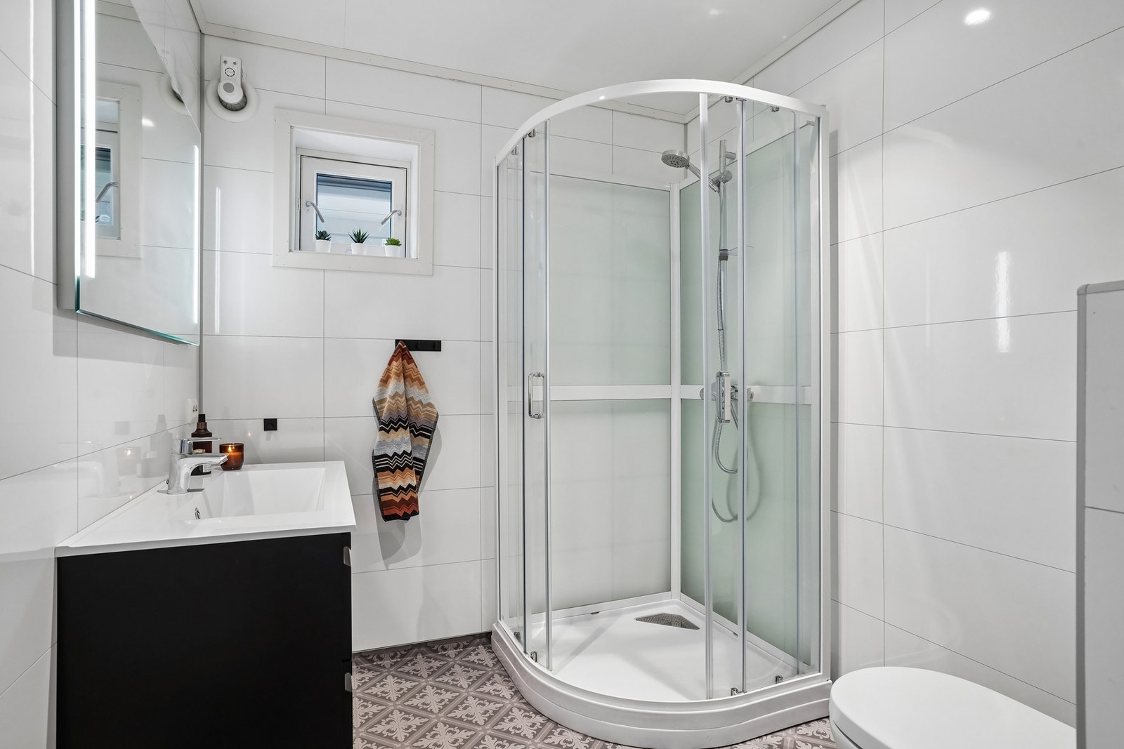 Badet i 2.etasje har vinylbelegg på gulv med elektriske varmekabler og baderomsplater på veggene. Galleribilde
