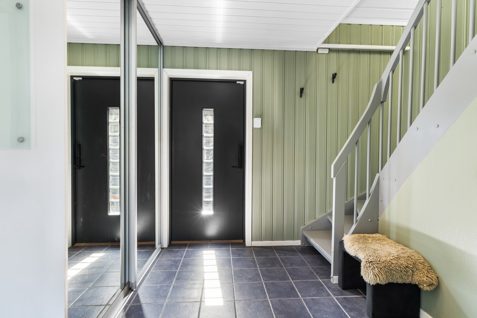 Du møtes av en lys og romslig entré som er flislagt med varmekabler. God plass til ytterklær i skyvedørsgarderobe. Galleribilde