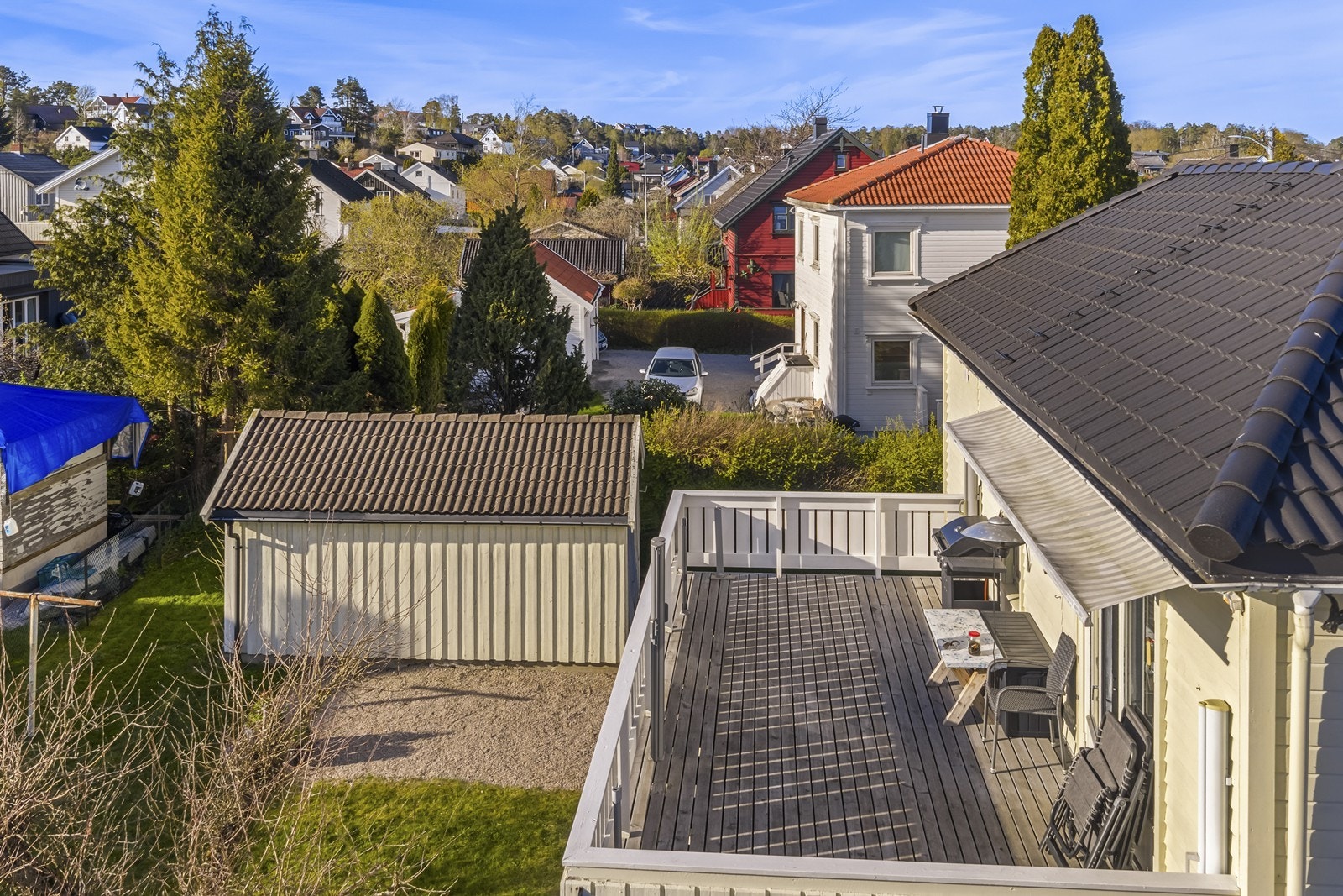 Utsikt fra terrassen i 2. etasje. På tomten står en eldre, frittstående garasje med bod. Galleribilde