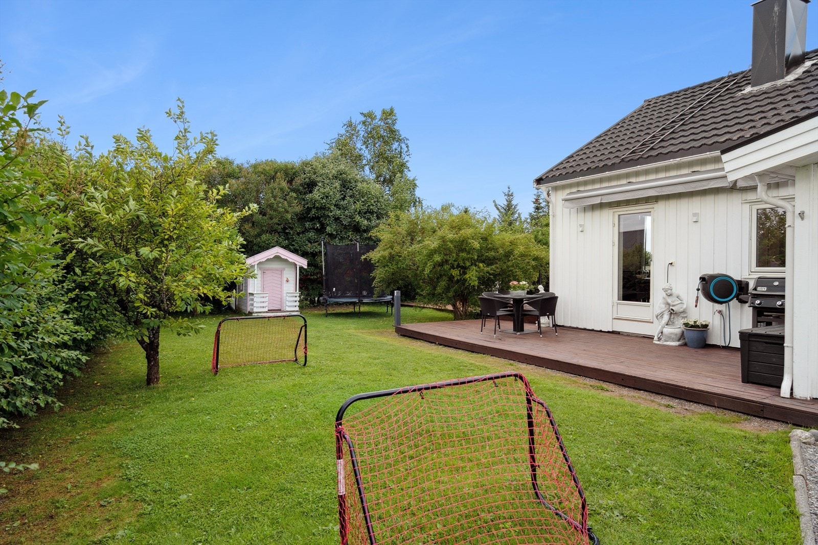 Flott hage med diverse beplantning og rom for lekeapparater til barna Galleribilde