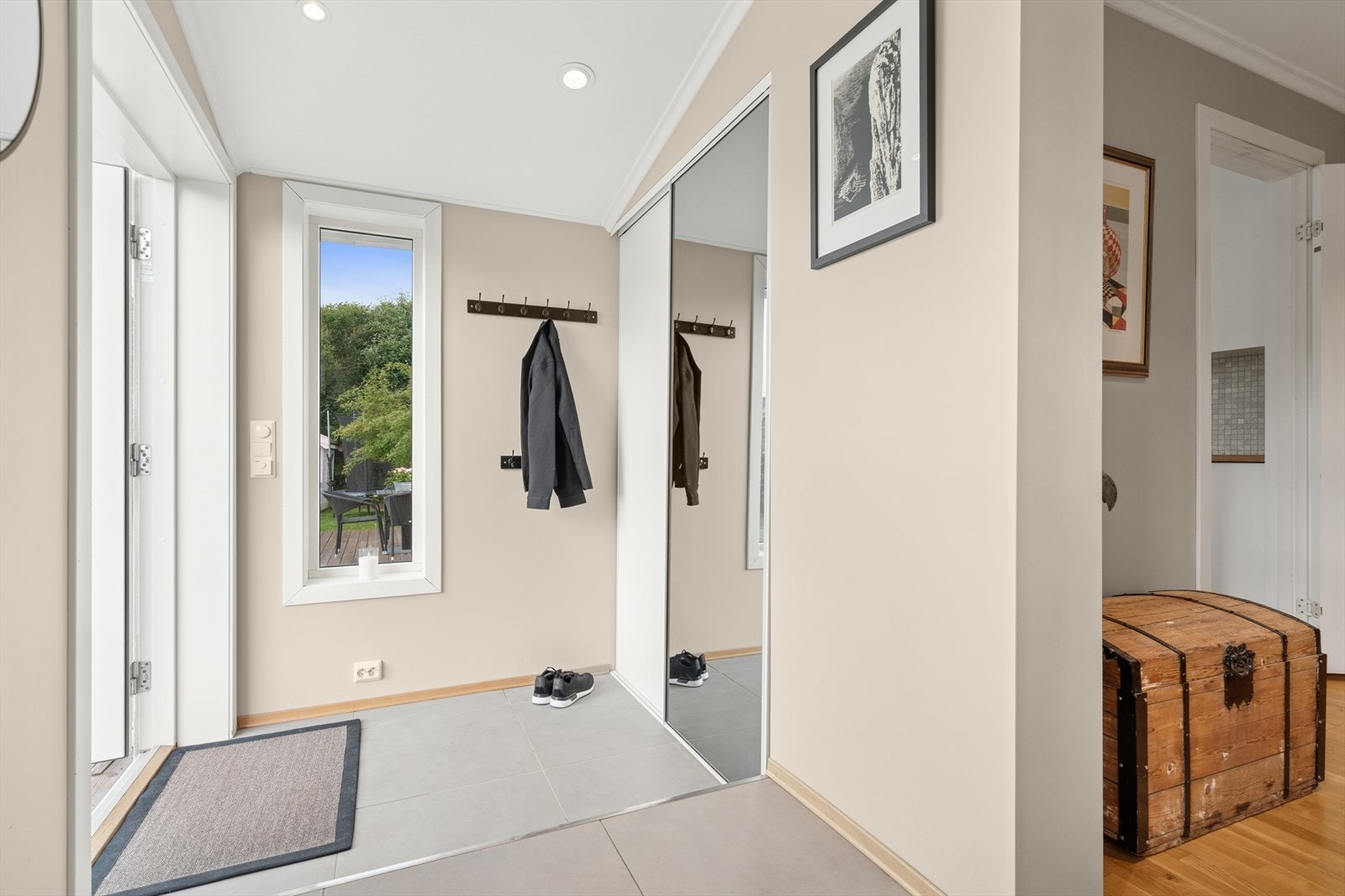 Du ønskes velkommen inn i en hyggelig flislagt entrè som er utstyrt med en praktisk skyvedørsgarderobe Galleribilde