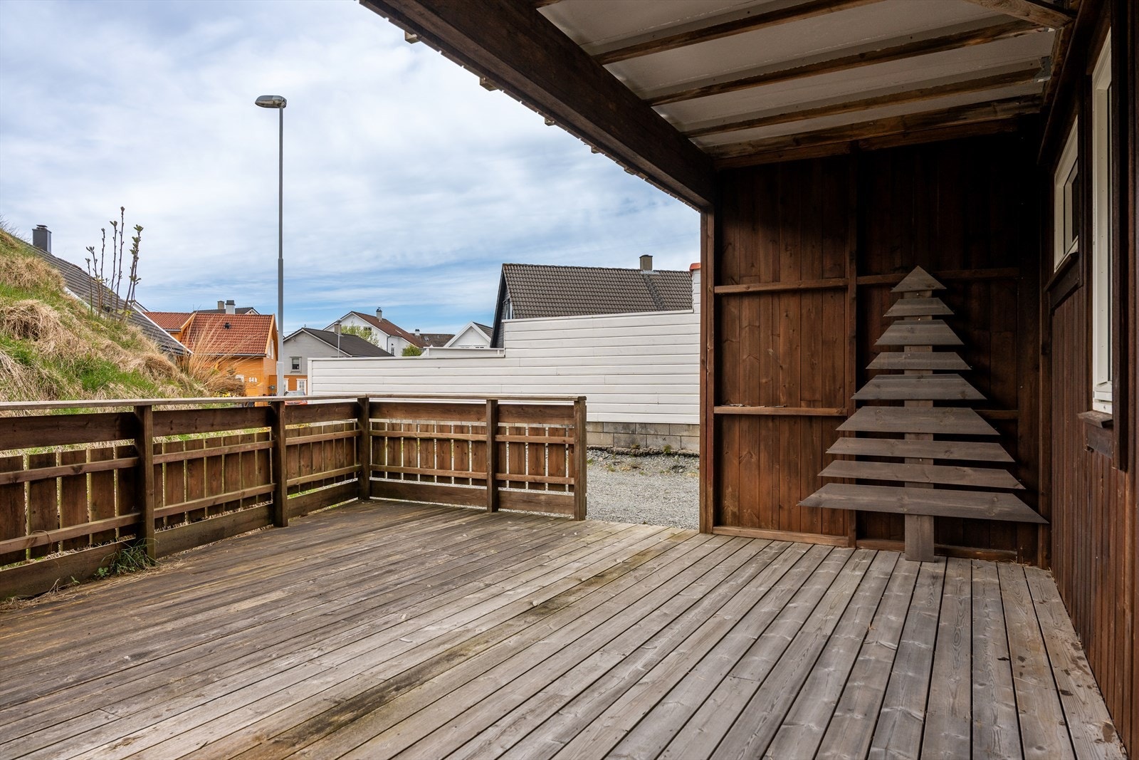 Romslig og delvis overbygget treterrasse i første etasje. Galleribilde