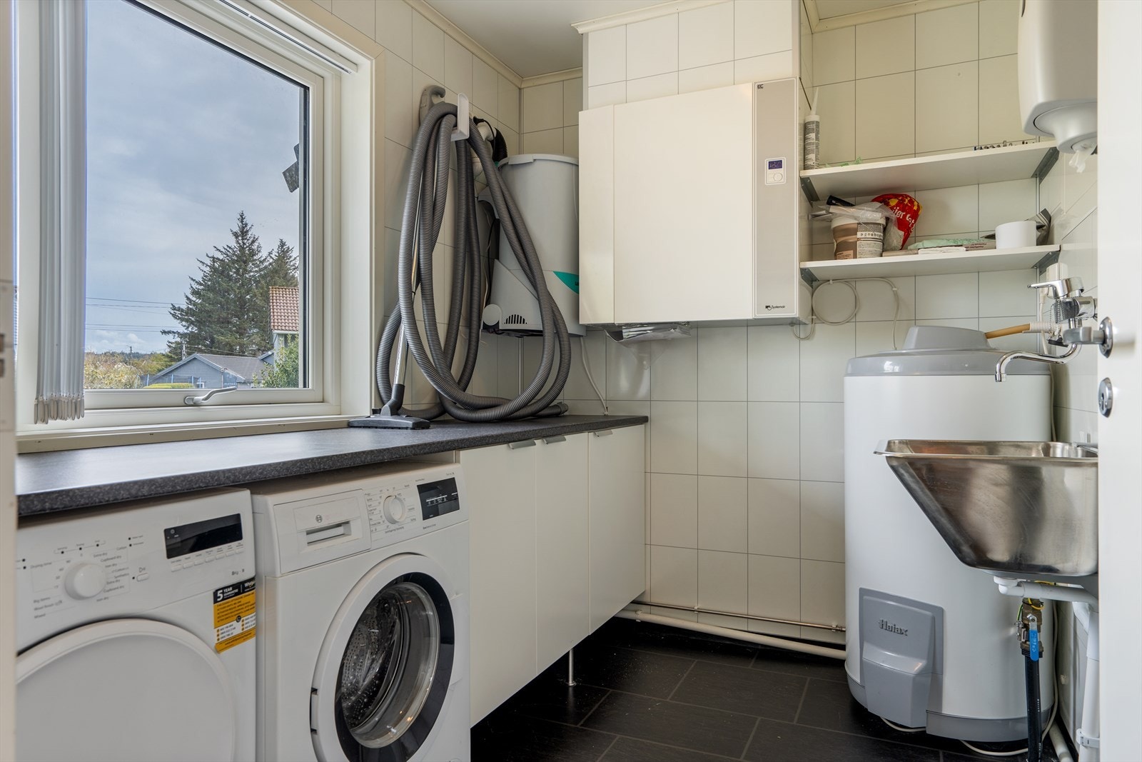 Separat vaskerom med opplegg for vaskemaskin, skap og utslagsvask. Galleribilde