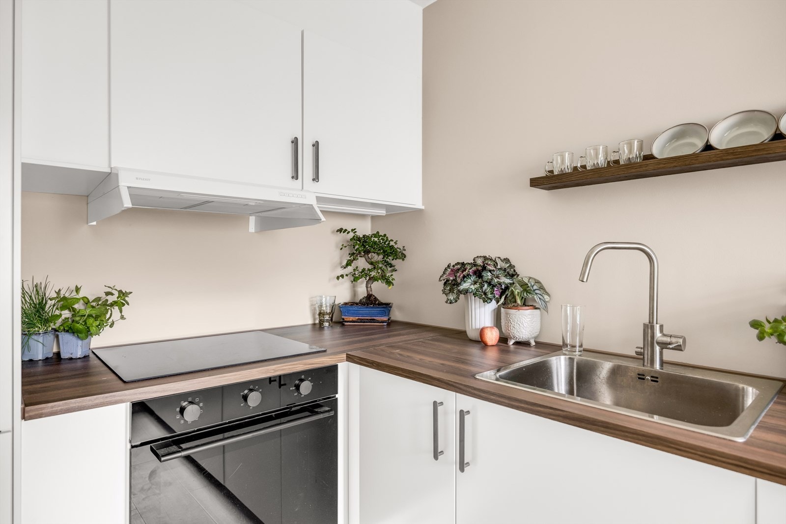Kjøkkeninnredningen har glatte fronter og laminat benkeplate med nedfelt vaskekum, som gir et moderne og funksjonelt uttrykk. Galleribilde