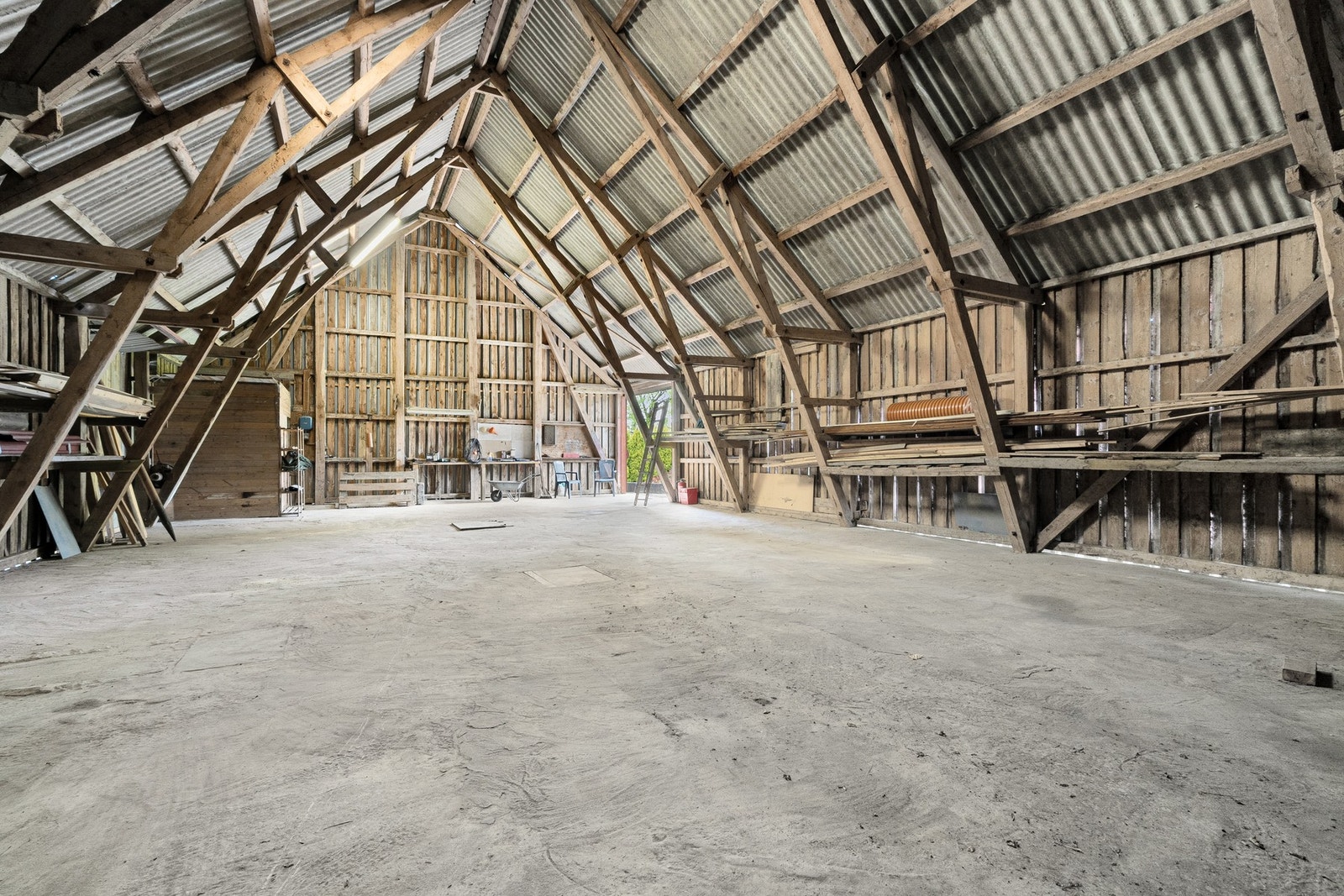 Loft i låven, betonggulv. Låven har vært benyttet til lagring av båter, campingvogn redskaper m.m. Galleribilde