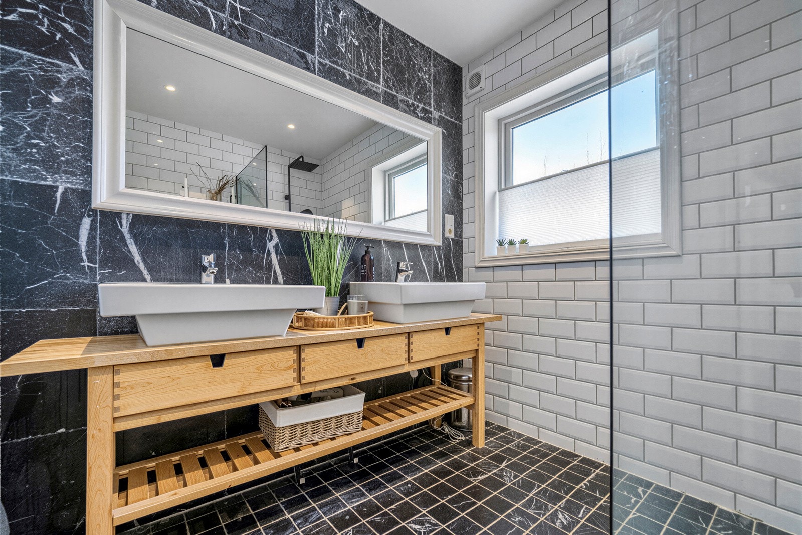 Badet er innredet med dobbel servant med innredning, dusj på gulv, samt vegghengt toalett. Galleribilde