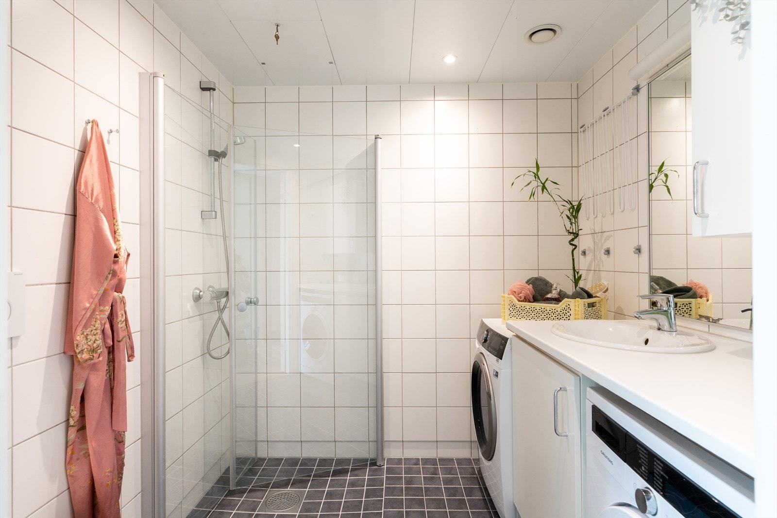 Badet fremstår som delikat og moderne med flislagte overflater, varmekabler i gulv og downlights i tak. Galleribilde