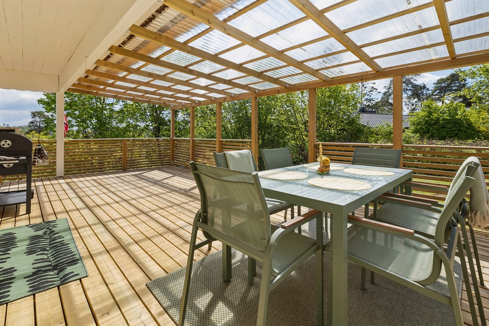 Stor terrasse med overbygd tak som skaper en lun og hyggelig uteplass med gode møbleringsmuligheter og fine forhold for lange sommerkvelder. Galleribilde