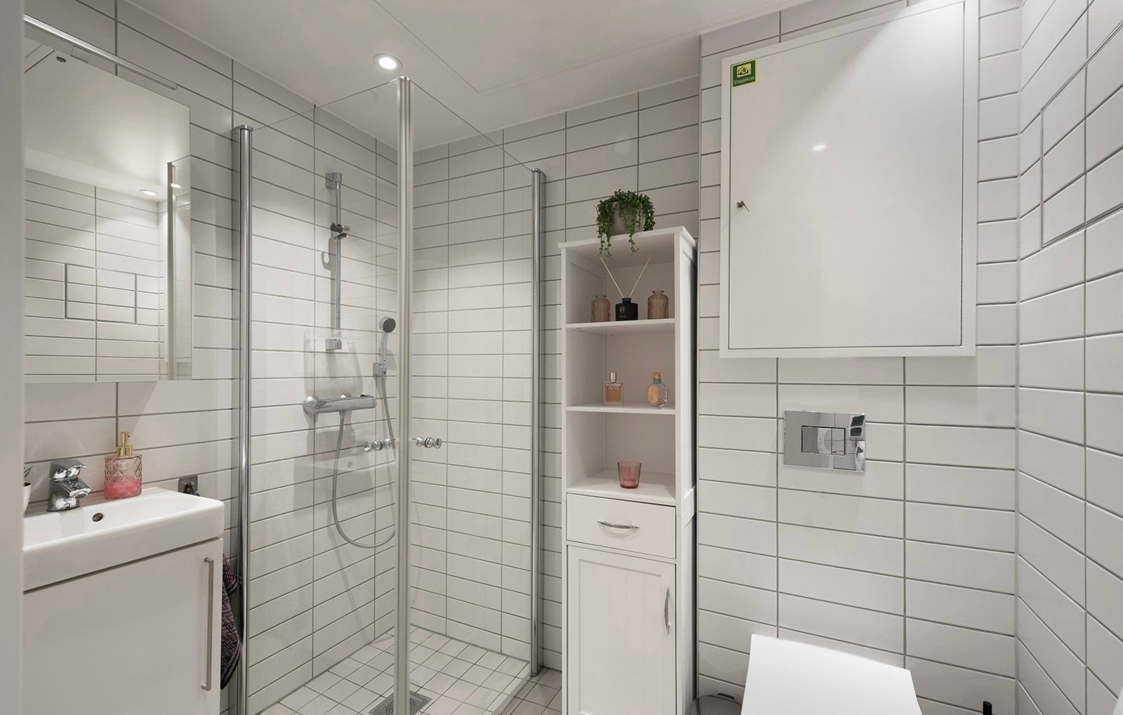 Leiligheten har et velholdt og delikat bad med downlights i himlingen, hvite fliser på veggene og matchende fliser på gulv med gulvvarme Galleribilde