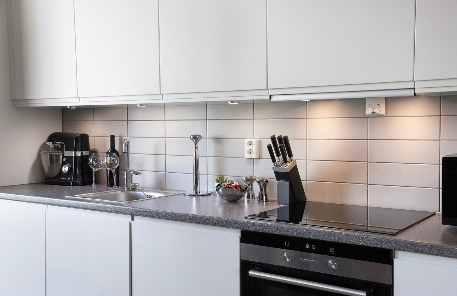 Kjøkkenet har et stilfullt og tidsmessig design med god benkeflate og mye oppbevaringsplass Galleribilde