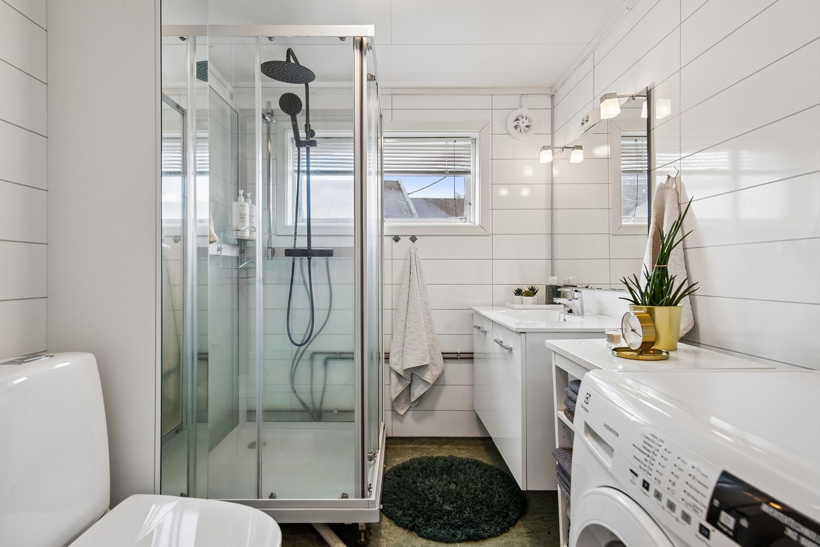 Badet er utstyrt med dusjkabinett, servant med underskap og har opplegg for vaskemaskin. Galleribilde