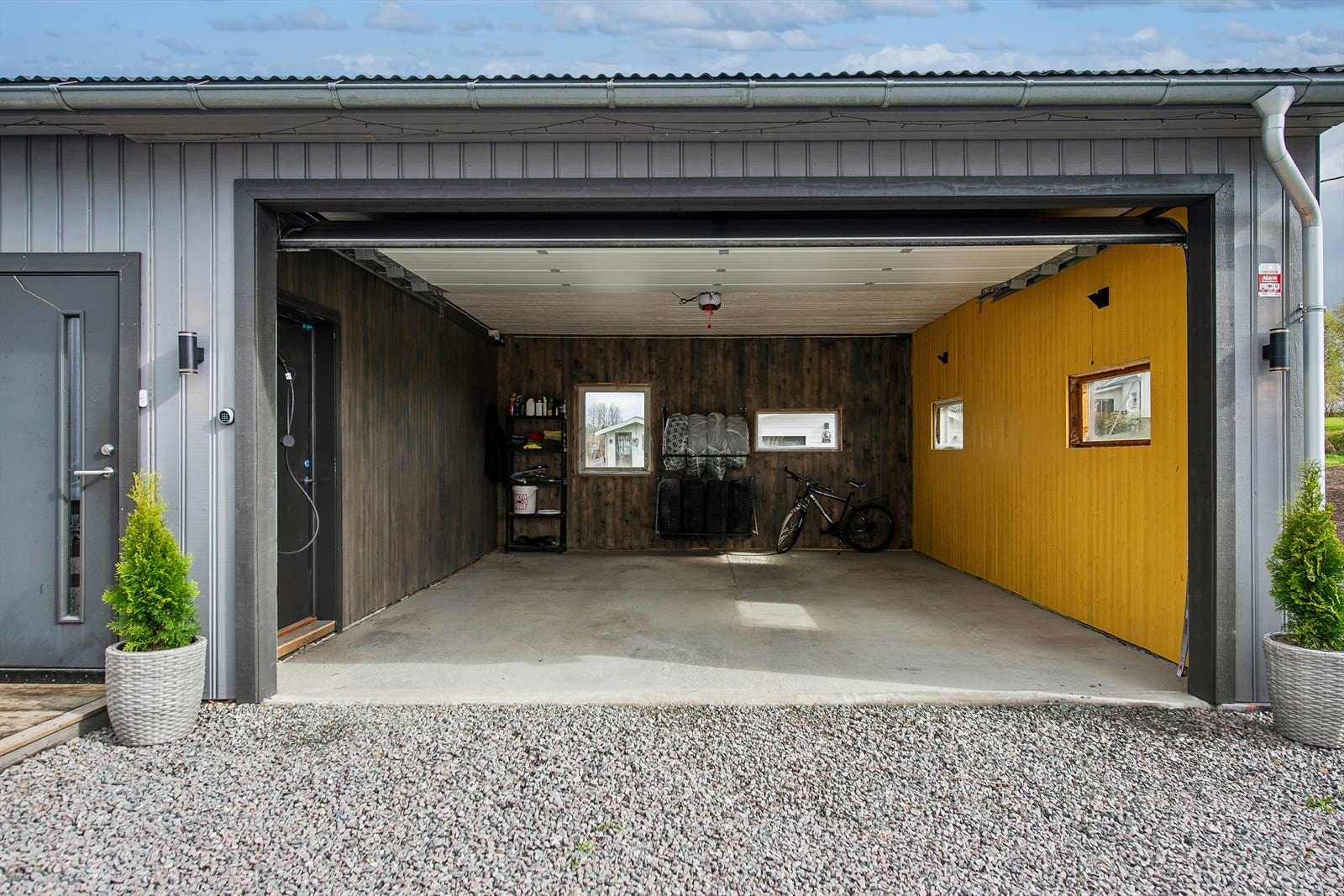 En av garasjeplassene har leddport av metall med automatisk portåpner. Galleribilde
