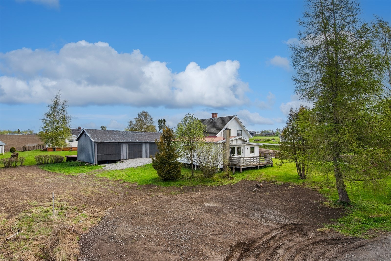 Eiendommen sett fra baksiden, med oversikt over hagen og uthusbygningen. Galleribilde