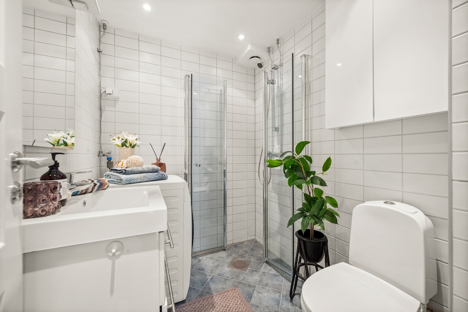 Badet har fliser på vegger og gulv, med elektrisk gulvvarme Galleribilde