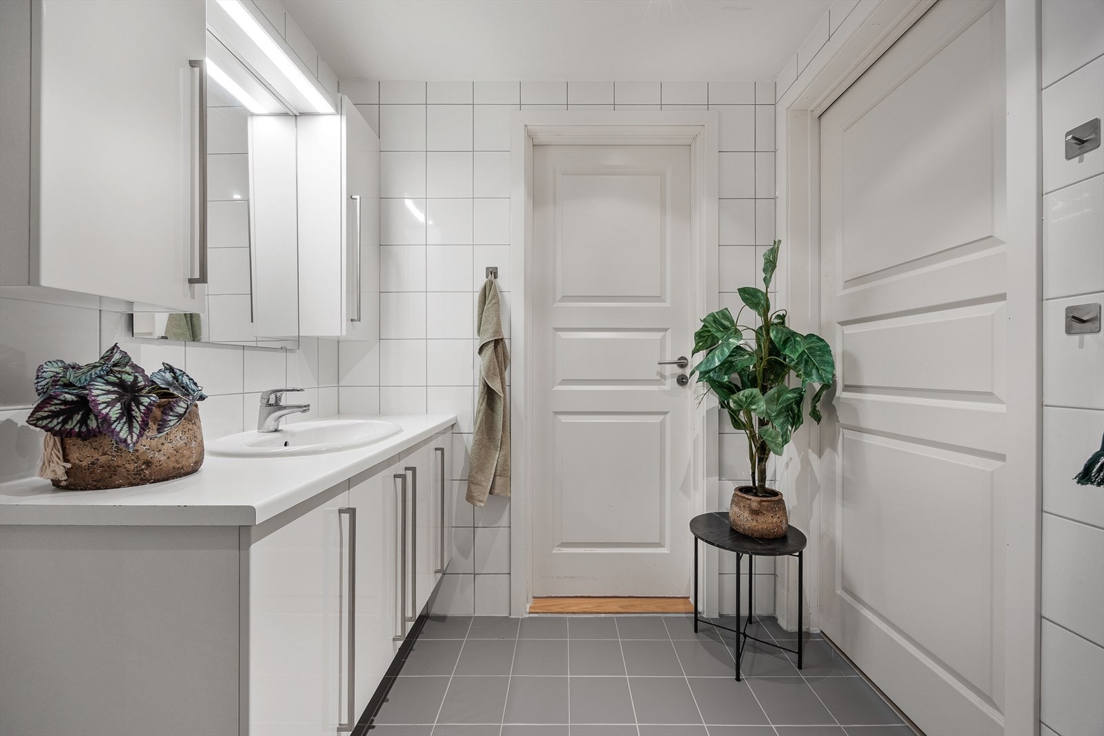 Badet er en prefabrikkert baderomskabin med flislagte overflater og elektriske varmekabler i gulvet. Galleribilde