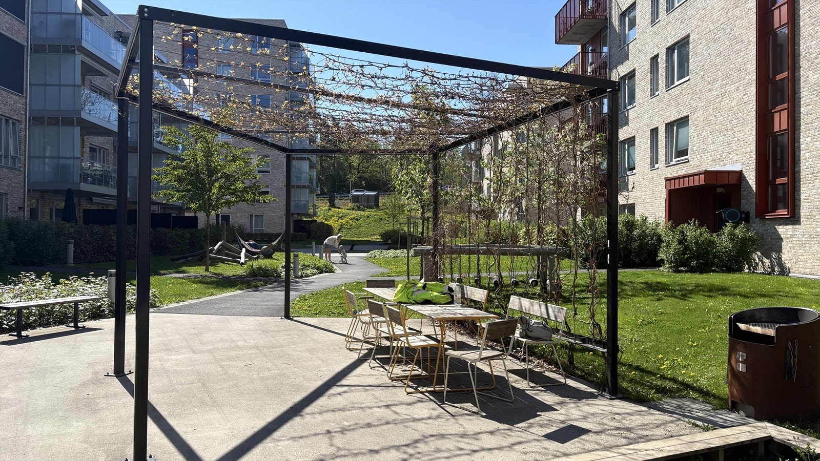 Stilig uteområde med pergola, perfekt for avslapning. Nærhet til grøntarealer og lekeplass, ideelt for familier. Selgers private bilde. Galleribilde