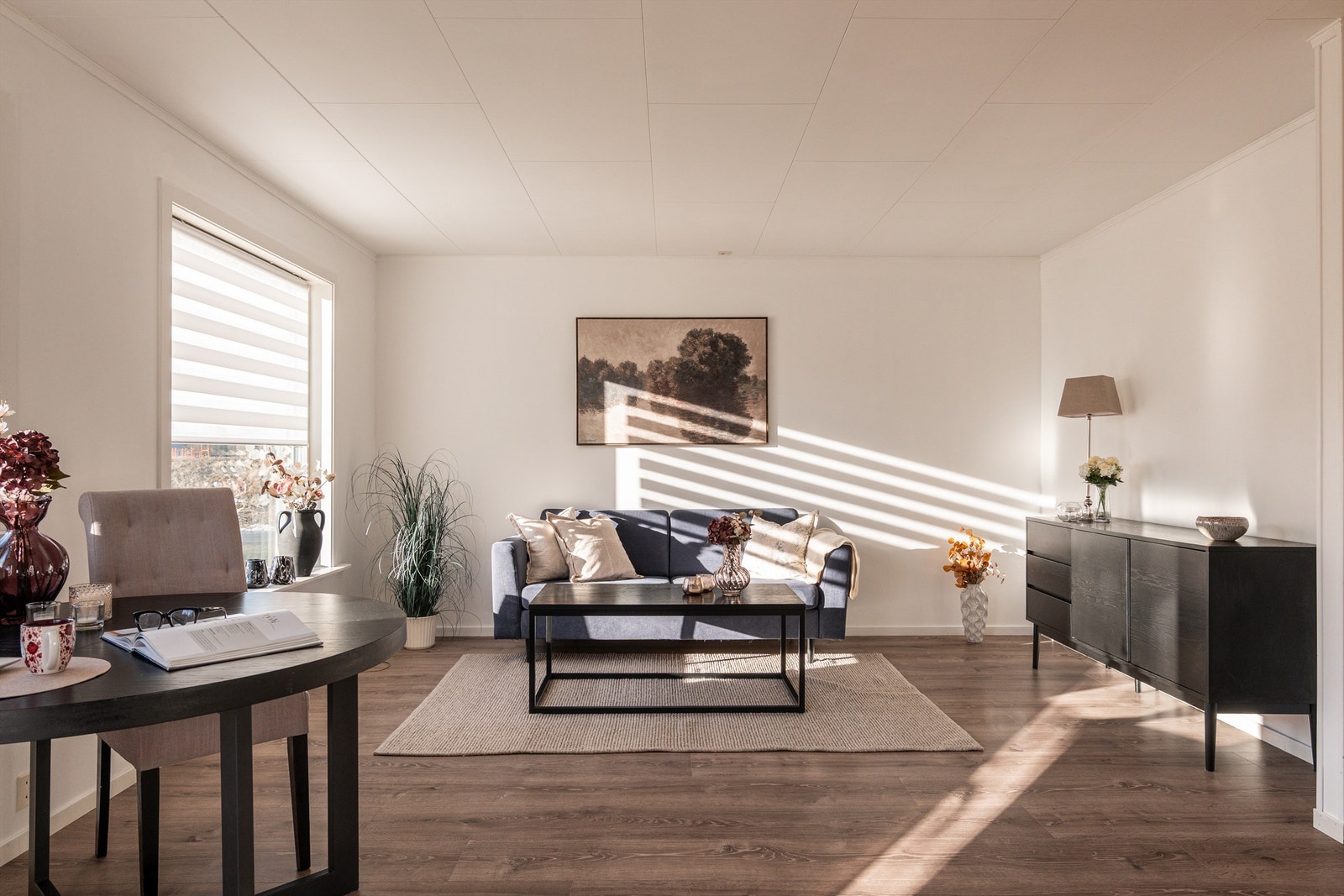 Oppholdsrommet har en naturlig inndeling med plass til både sittegruppe og spisebord. Galleribilde