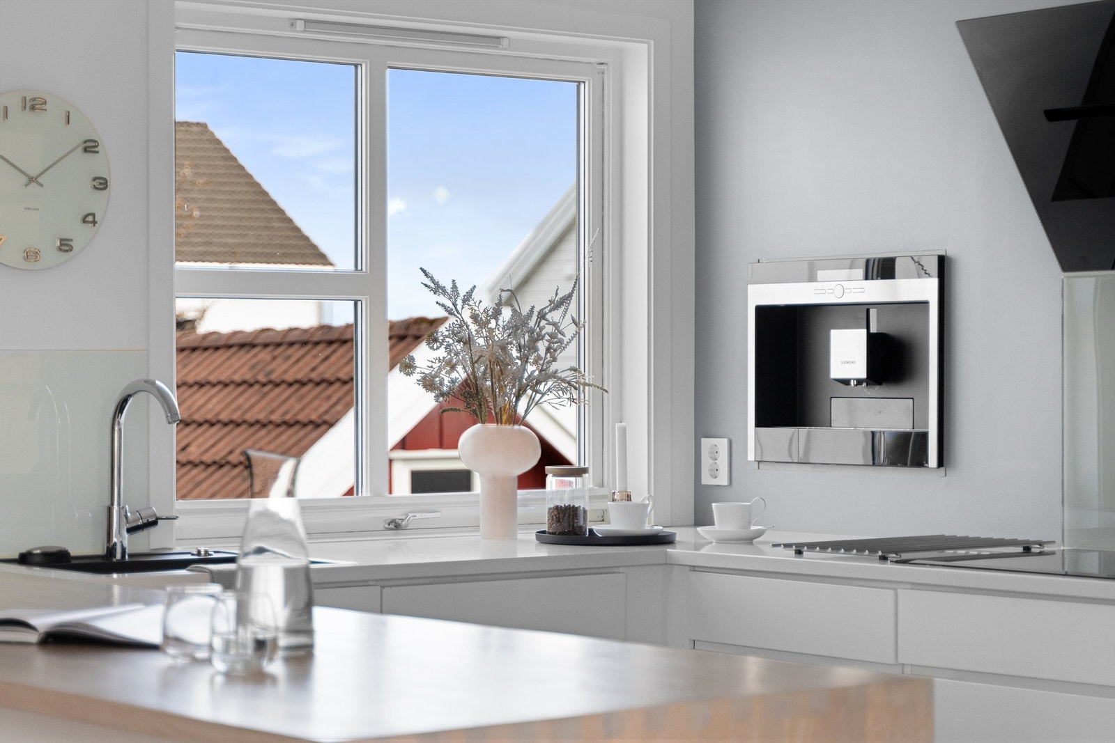 Innredning er tidløst i hvit med heltre benkeplate på kjøkkenøy, kompositt benkeplate på resten av benken, integrerte hvitevarer som koketopp, komfyr, kjøleskap, oppvaskmaskin, kaffemaskin. Galleribilde