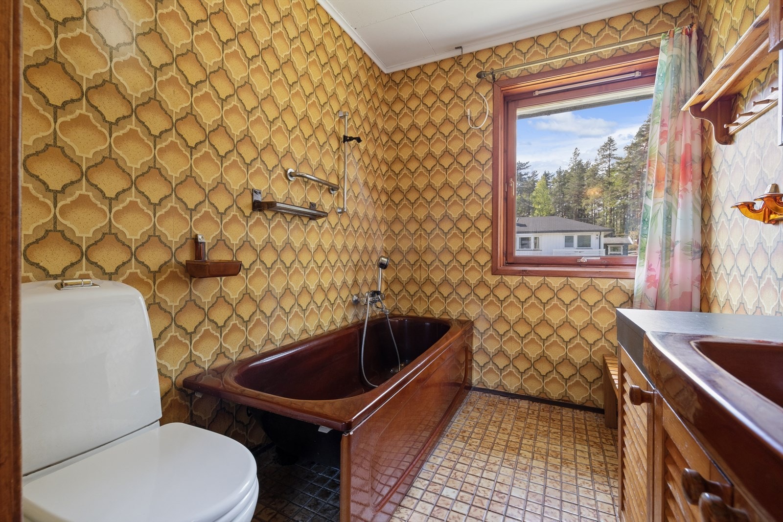 Badet er utstyrt med toalett, badekar med dusj, baderomsinnredning med servant og blandebatteri, samt speil med lys. Galleribilde