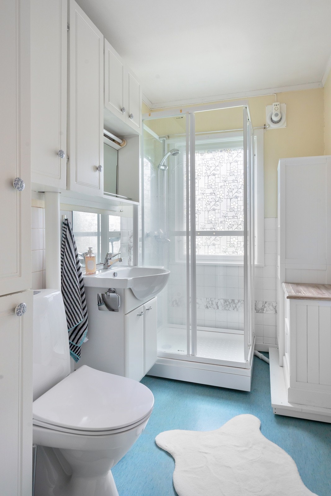 Badet i 1. etasje er fra antatt byggeår og har godt med skapoppbevaring, dusjkabinett og avtrekksvifte. Galleribilde