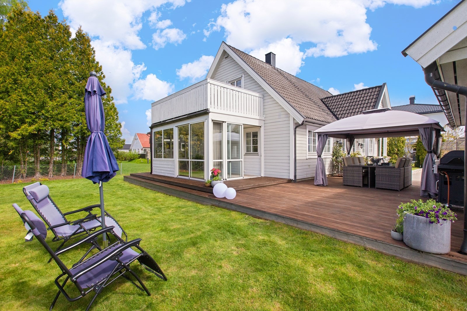 Enebolig fra 1996 med en stor terrasse på mark og en innglasset hagestue som forlenger utesesongen. Galleribilde