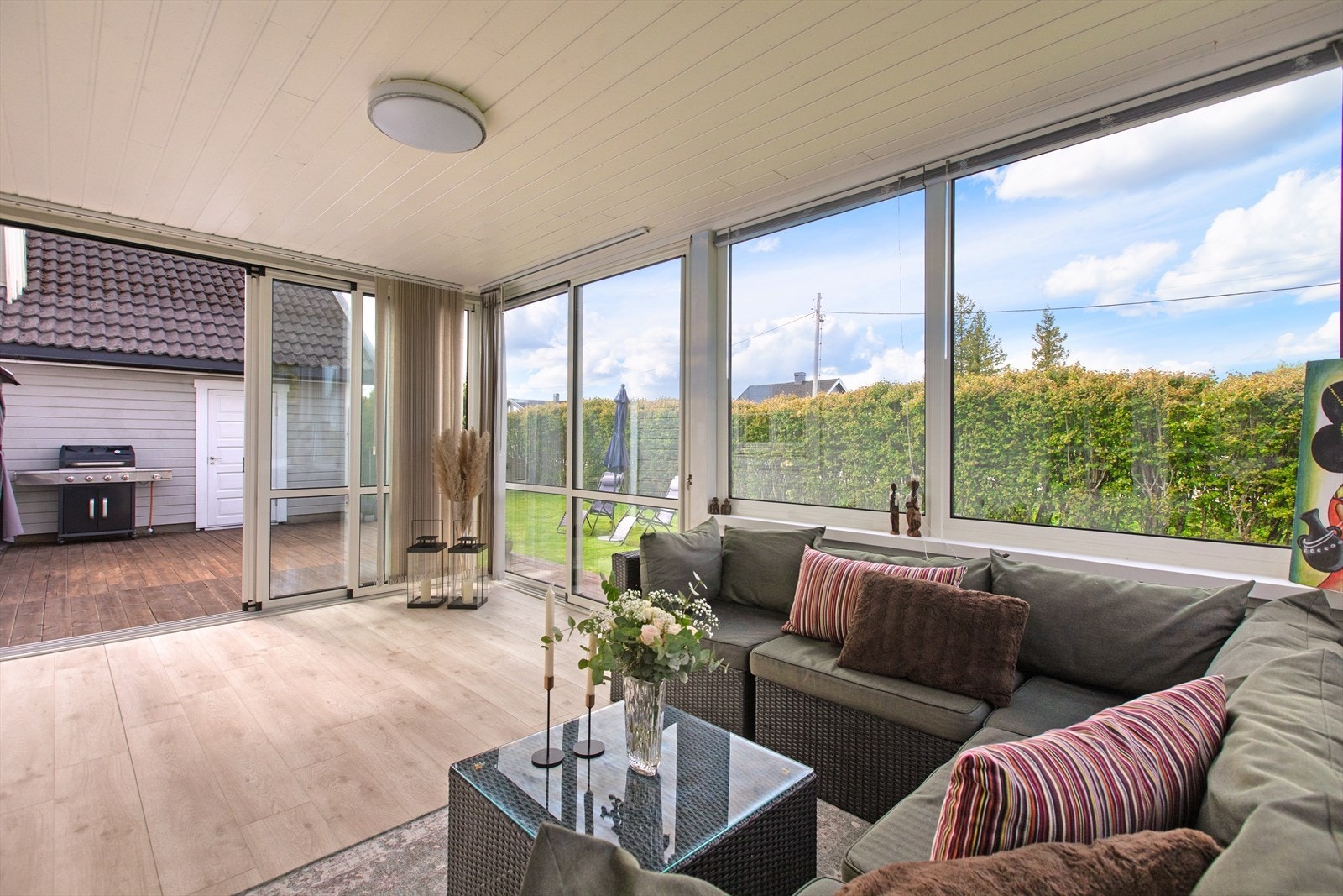Skyvedører i glass kan åpnes helt opp mot den store terrassen og hagen. Galleribilde