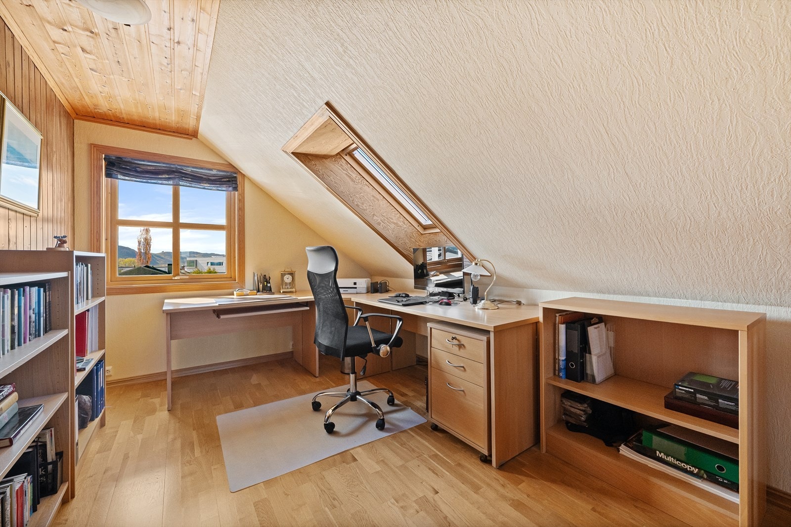 En del av loftstuen er innredet som en praktisk kontorplass med godt lys fra takvindu. Galleribilde
