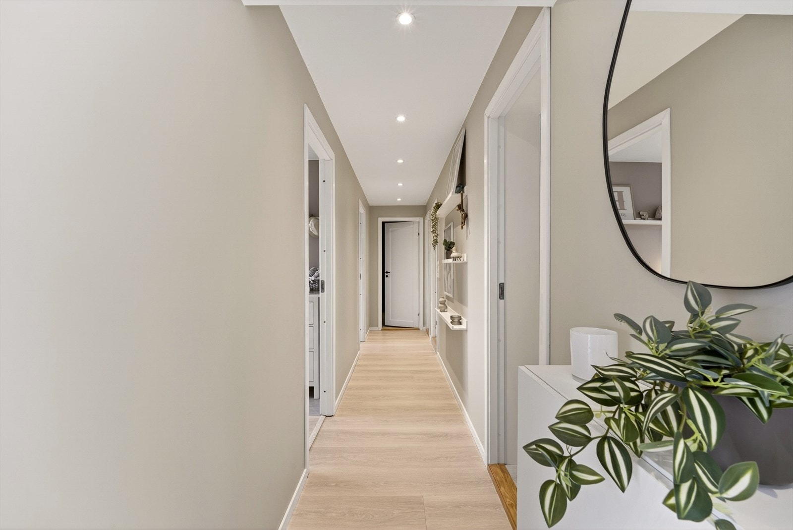 Moderne fargevalg, lys laminat og gjennomgående downlights bidrar til et stilrent uttrykk. Galleribilde