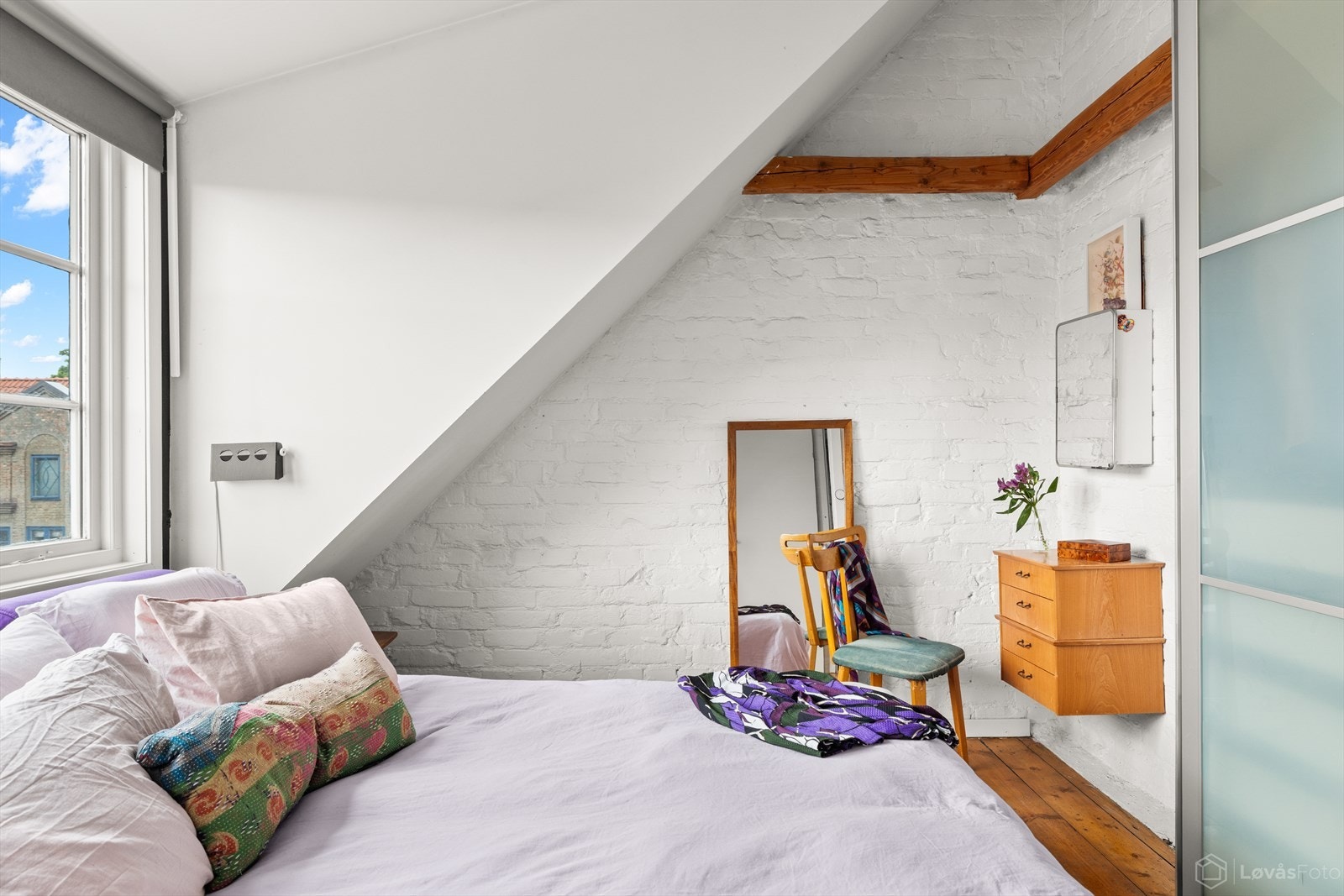Sjarmerende klassiske detaljer som synlige trebjelker, tregulv og malte teglvegger gir boligen et varmt og karakterfullt uttrykk. I tillegg er rommet utstyrt med en praktisk skyvedørsgarderobe og "walk-in". Galleribilde