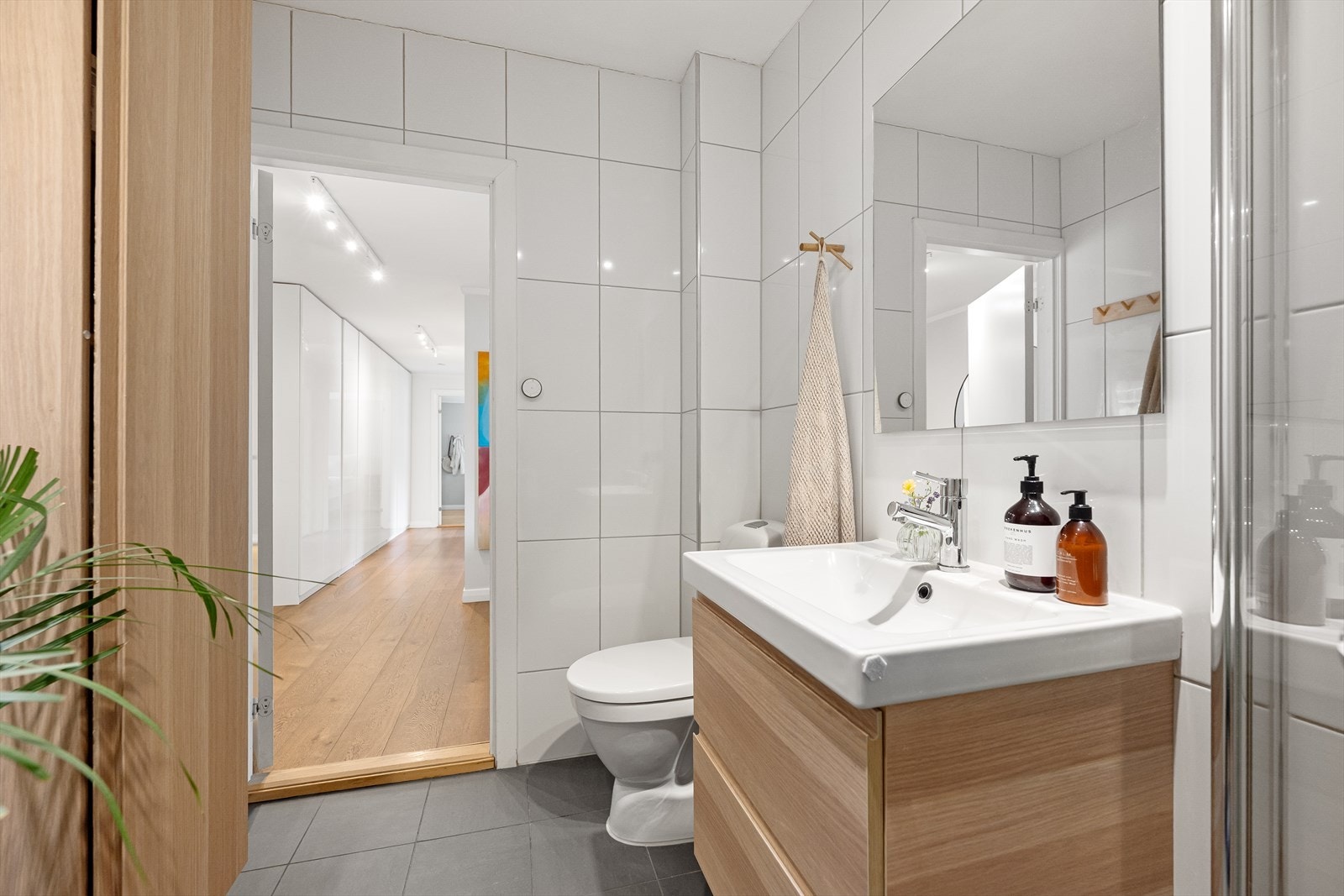 Badet er innredet med servant med skuffer, dusj med glassdører og vegghengt toalett. Innredningen er av nyere dato Galleribilde