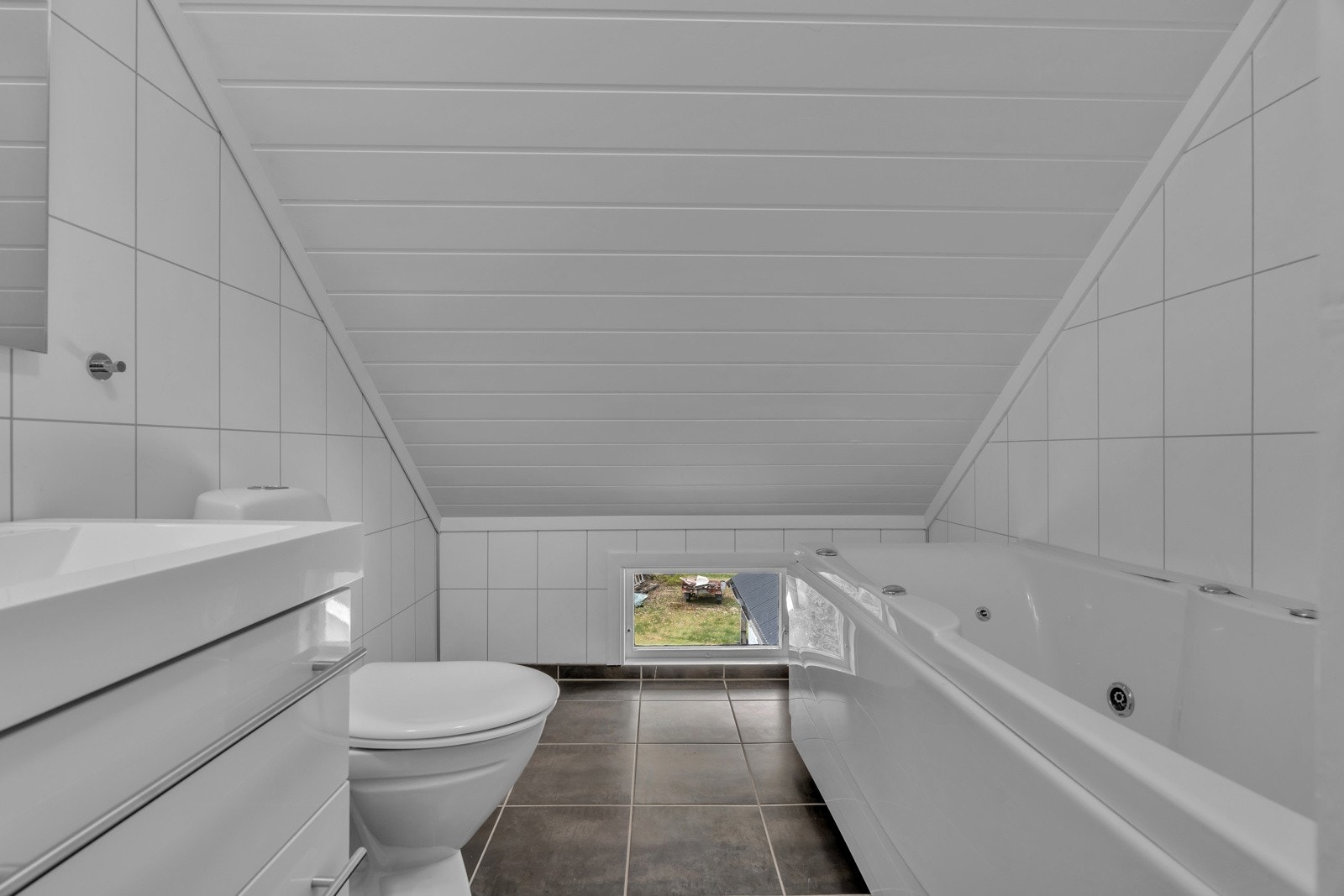 Badet er pusset opp i den senere tid med flis og varmekabler på gulvet, fliselagte vegger og innredning med boblekar. Galleribilde