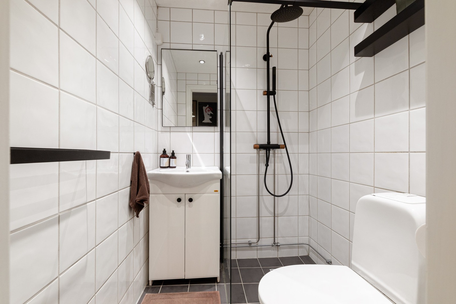 Flislagt bad med hvite og grå fliser på henholdsvis gulv og vegger. Badet ble pusset opp i regi av sameiet i 2005 Galleribilde