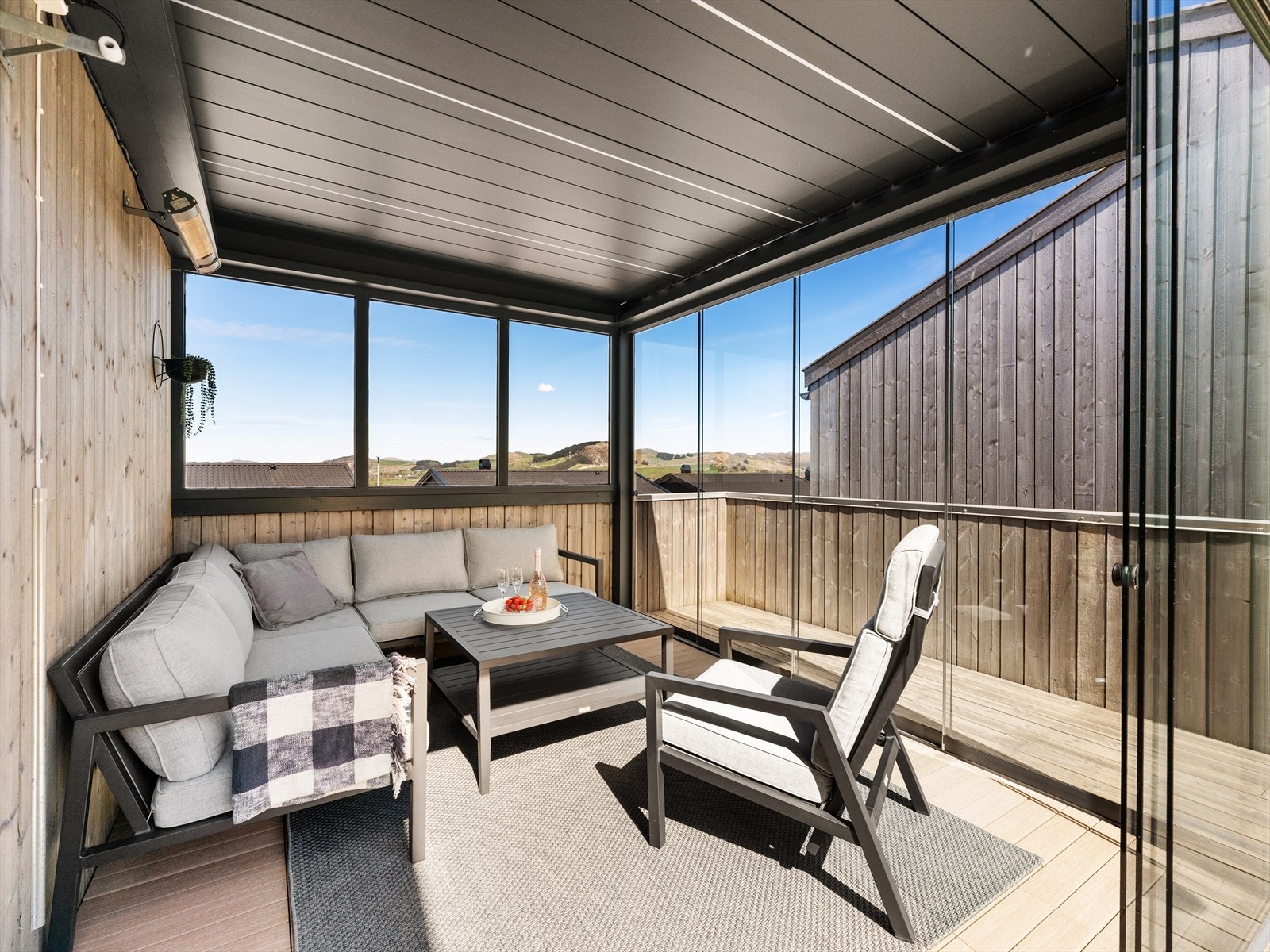 Et lunt og skjermet uterom med tilkomst fra stuen og videre utgang til takterrassen over carporten. Galleribilde