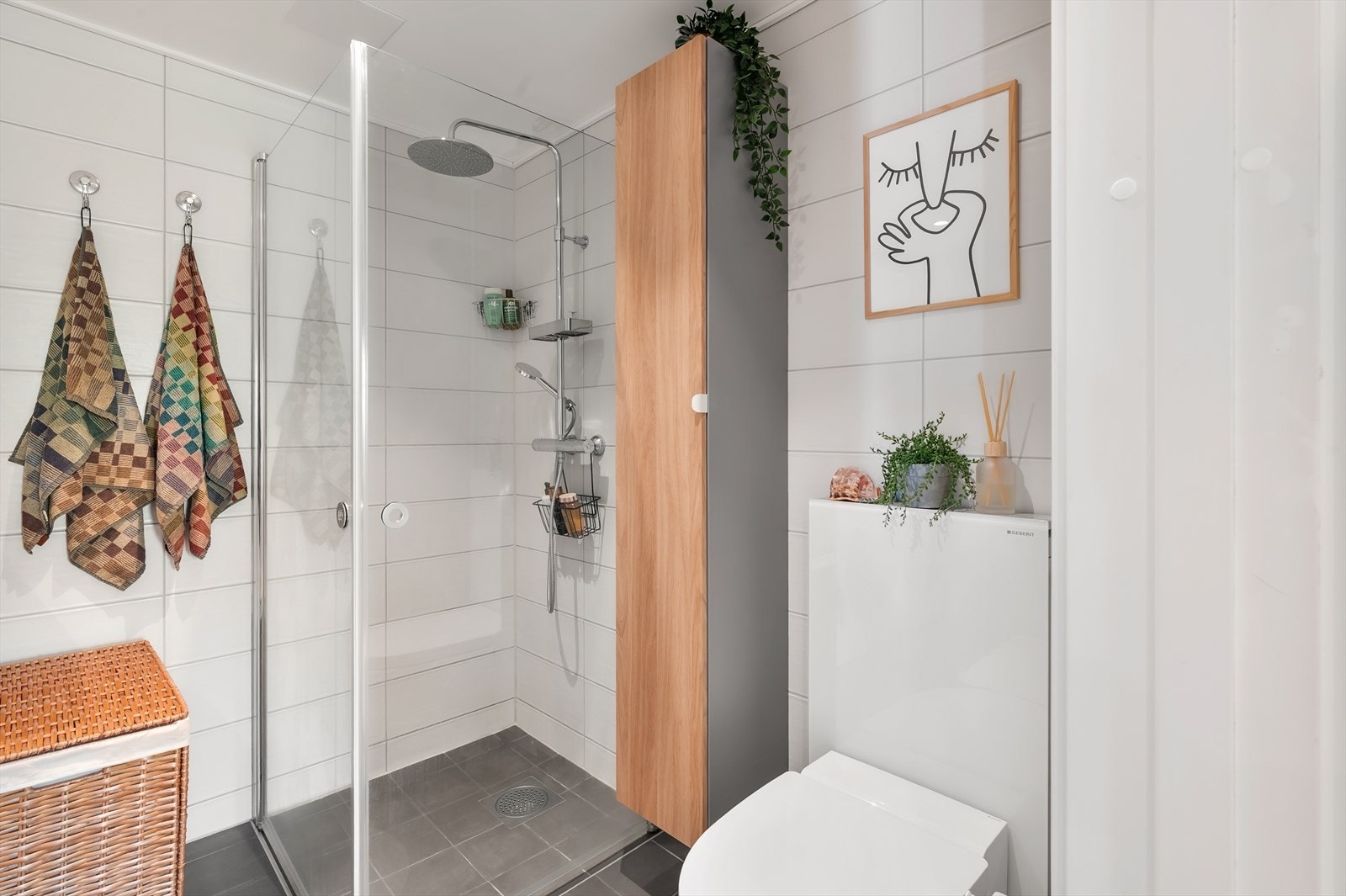 Videre er badet utstyrt med vegghengt dusjtoalett fra 2023 og dusjsone med innfelte dusjdører i herdet glass. Galleribilde
