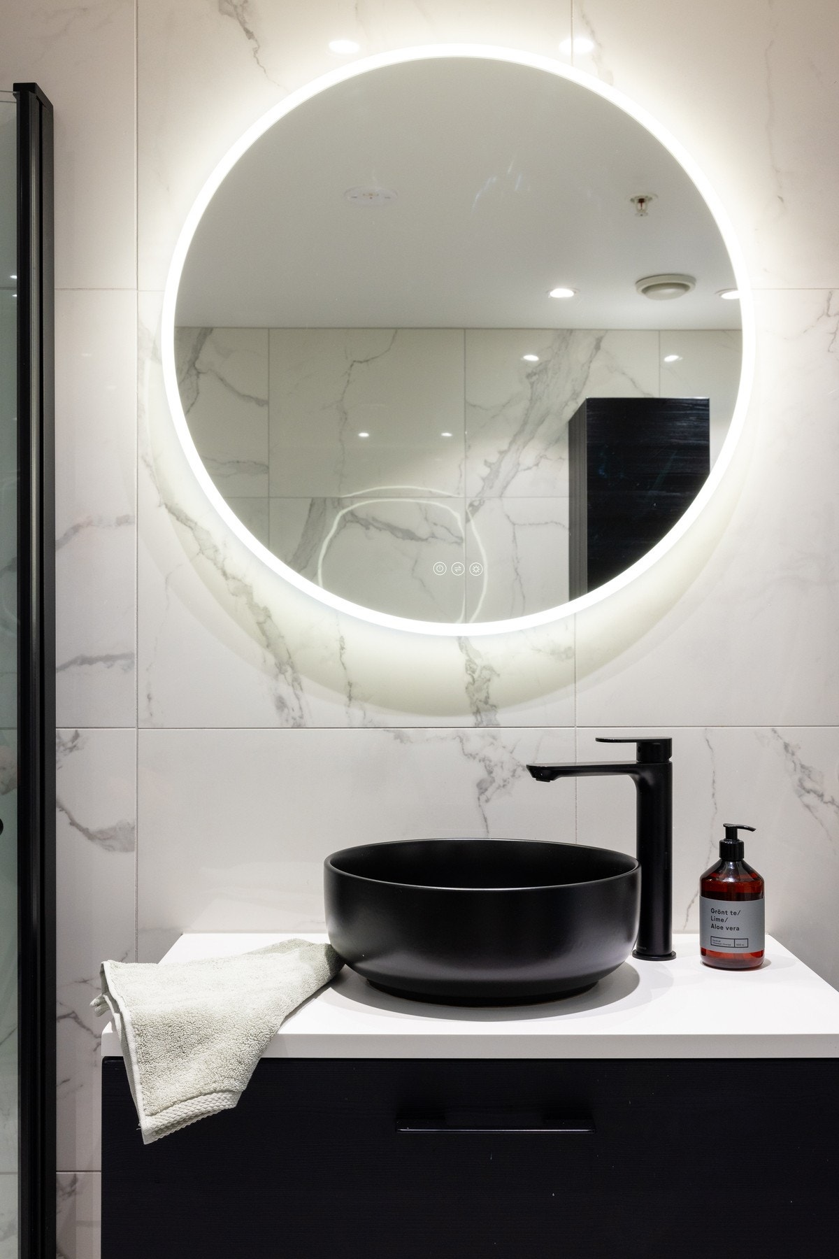 Badet er innredet med ovenpåliggende servant på underskuffer og speil med integrert belysning. Galleribilde