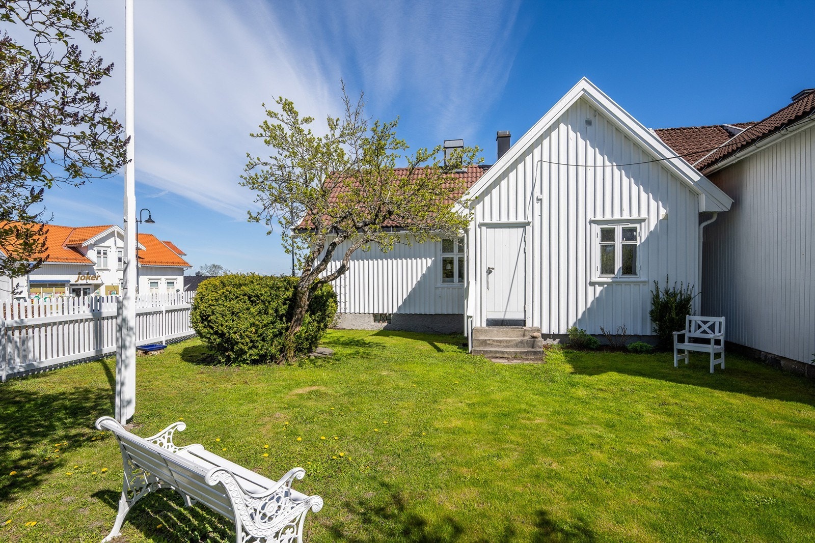 Hagen er pent opparbeidet med plen, syriner, roser og egen flaggstang. Galleribilde