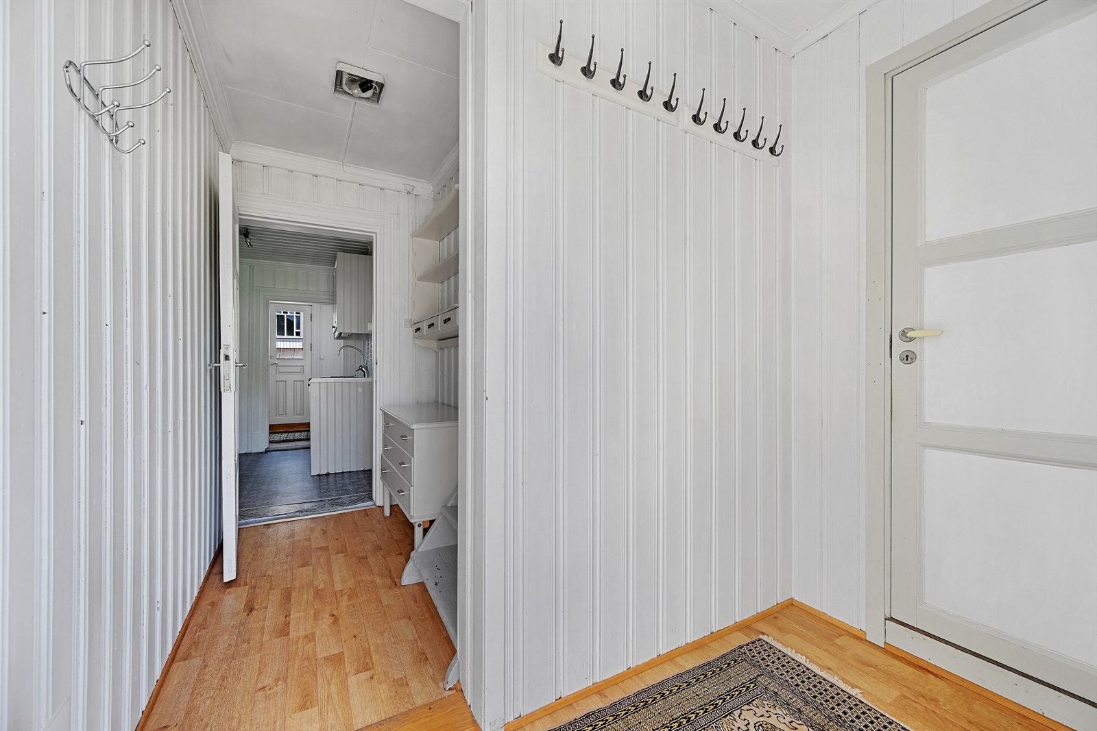 Gangen har malte panelvegger og plass til yttertøy. Galleribilde
