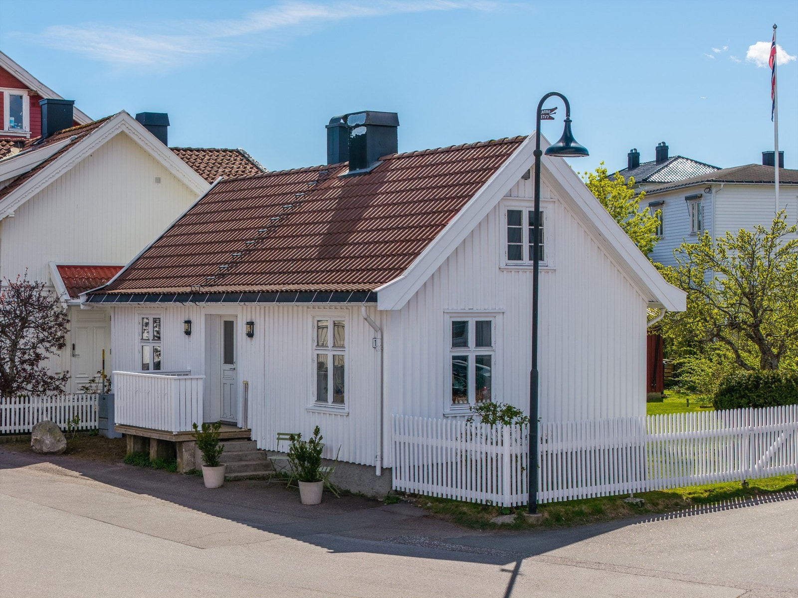 Eneboligen har en klassisk fasade med stående bordkledning og tak tekket med betongtakstein. Galleribilde